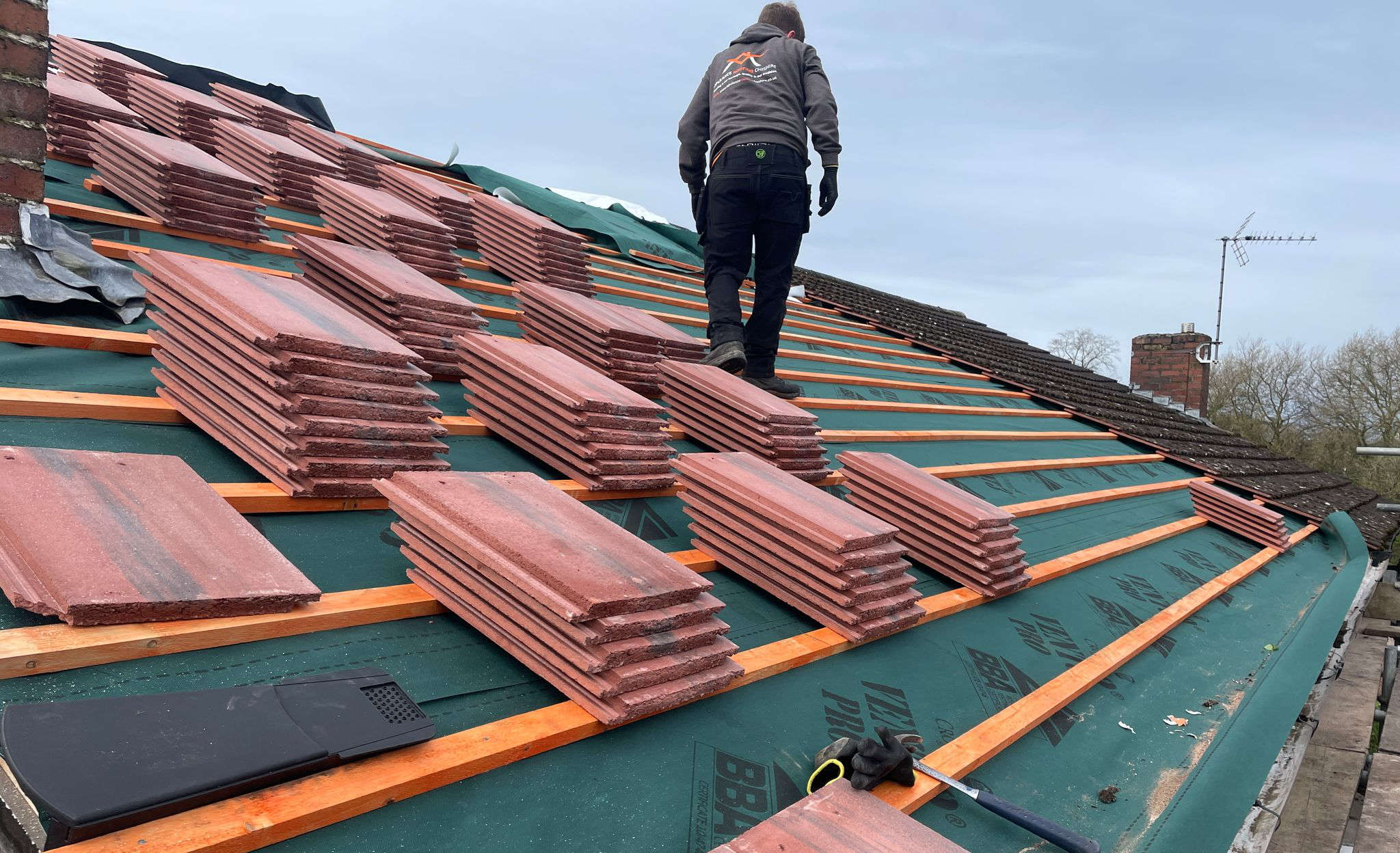 Professional roofer working on a UK residential roof